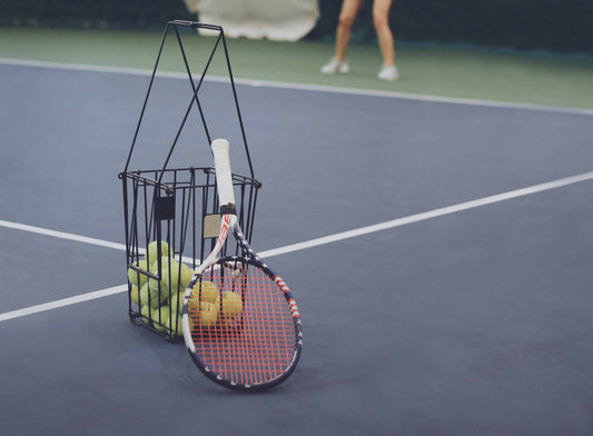 Bucket of balls with a tennis racquet