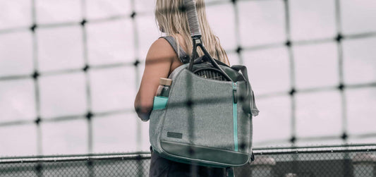 Woman wearing the mebourne tennis bag behind a net