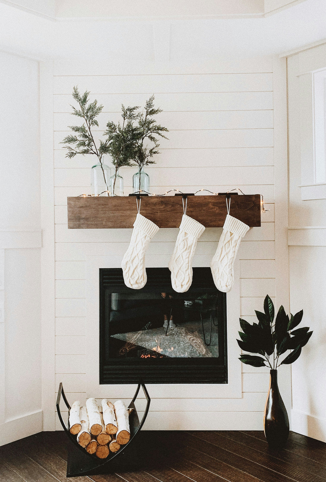 3 white stockings on a fireplace mantle